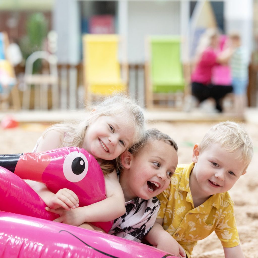 Children playing with an inflatable flamingo at Silverburn's Flamingo Beach.
